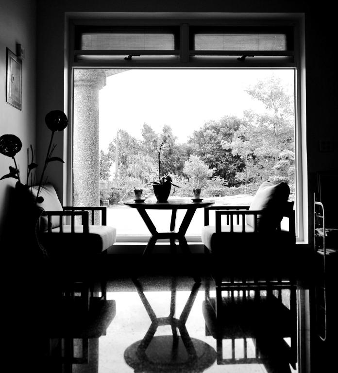 a living room with a table and a large window at Campestral Garden in Jiaoxi