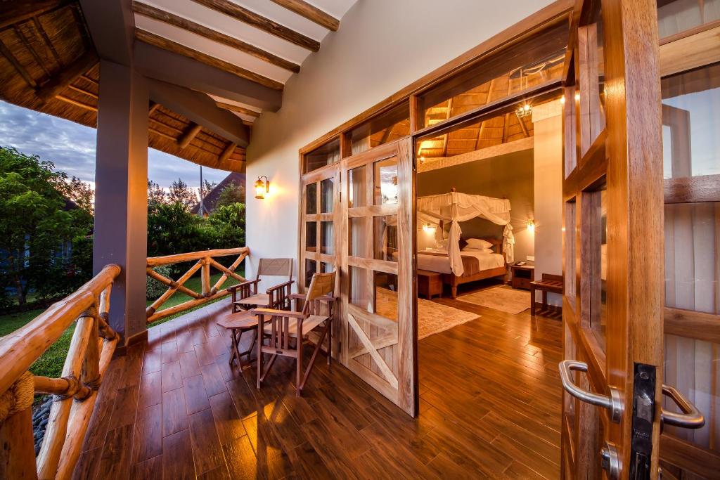 een kamer met een balkon met een bed en een slaapkamer bij Emburara Farm Lodge in Mbarara