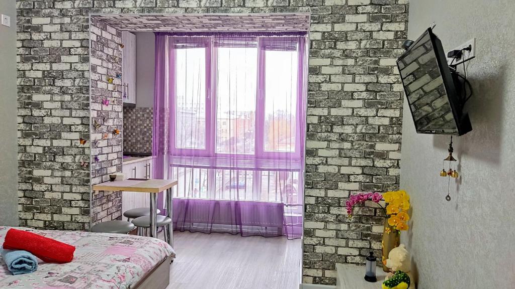 een slaapkamer met een bakstenen muur en een raam bij Миниотель в Харькове, ЮЖД in Charkov