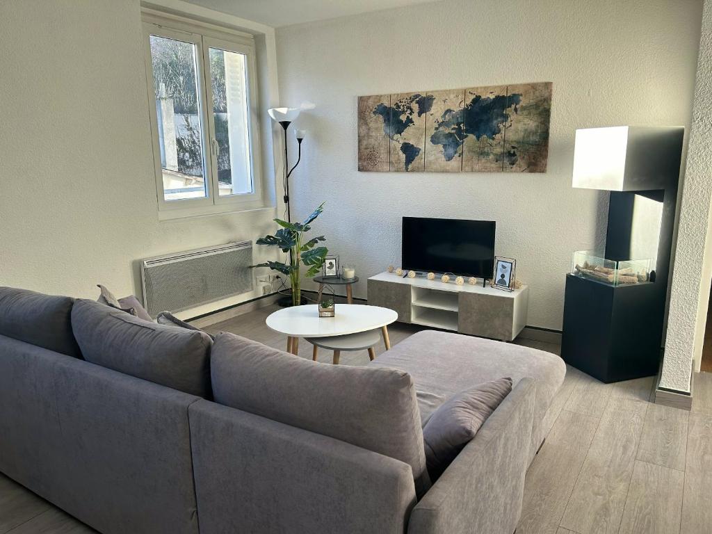 a living room with a couch and a table at Appartement charmant à Luzenac - 60m² - Confort moderne in Luzenac
