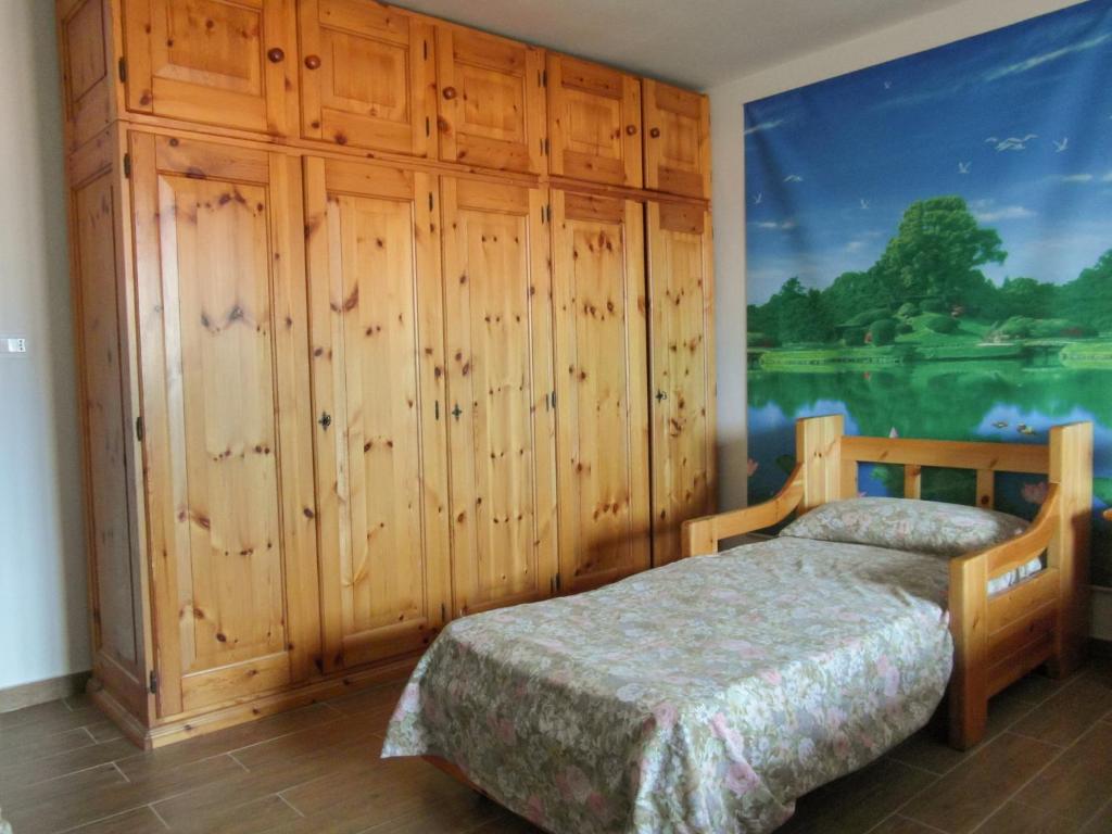a bedroom with a bed and a large painting on the wall at La piccionaia in Aosta