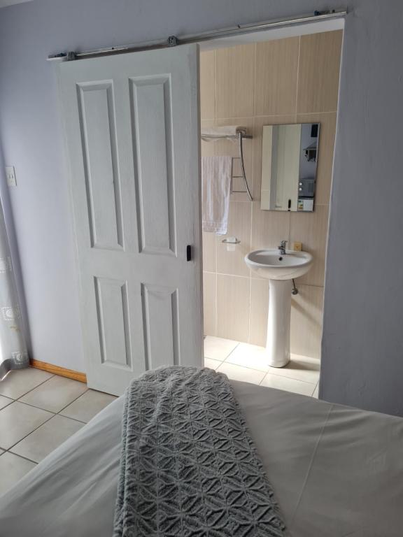 - une chambre avec un lit et une salle de bains pourvue d'un lavabo dans l'établissement Mews Road Self-Catering, à Queenstown
