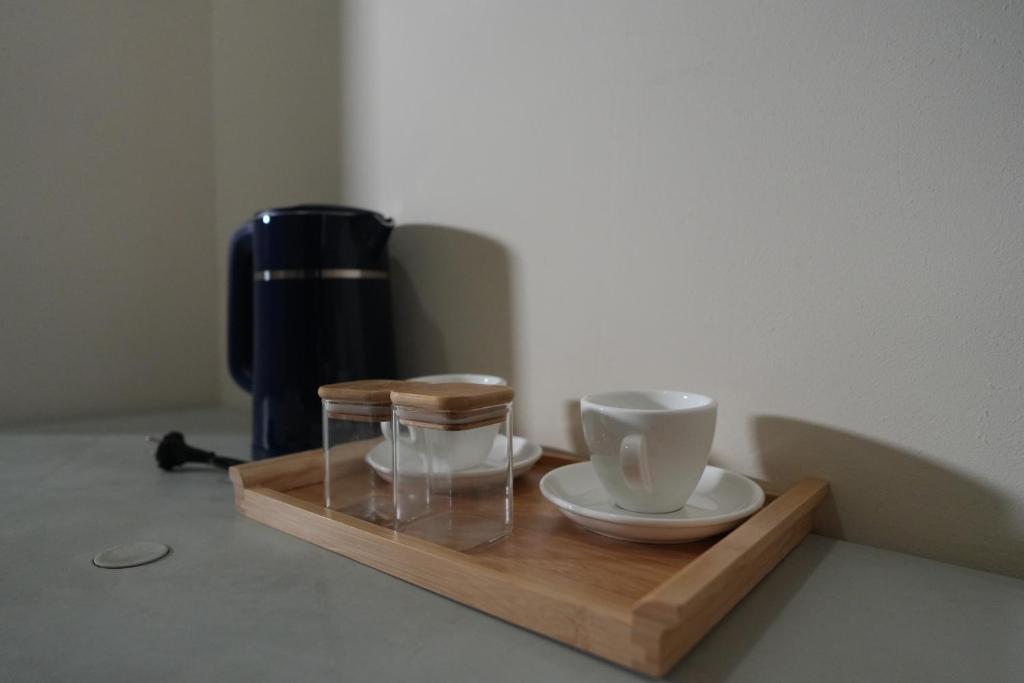 a wooden tray with two cups and a coffee maker at Balcony Hotel in Tbilisi City
