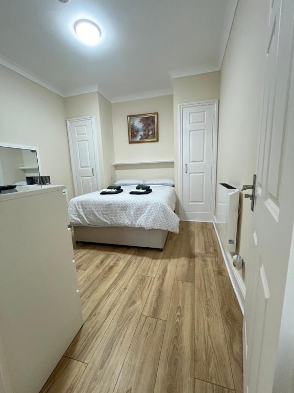 a bedroom with a bed and a refrigerator at Station Lodge in London