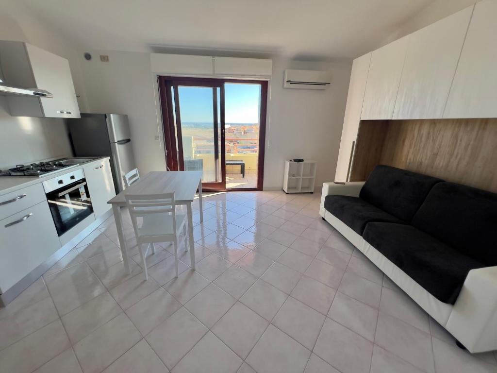 a kitchen and living room with a couch and a table at Casa di Jack I.U.N. R6217 in Quartu SantʼElena