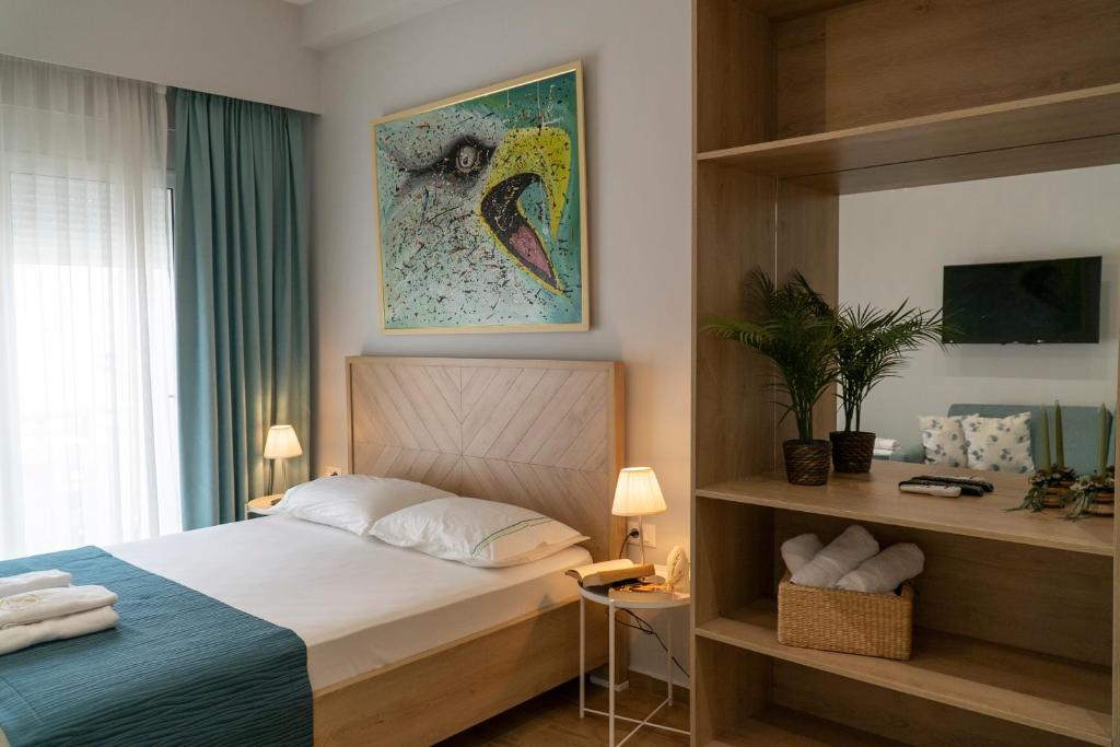 sypialnia z łóżkiem, telewizorem i oknem w obiekcie Oyster Apartments w Sarandzie