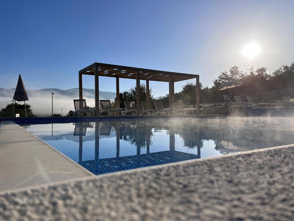 uma piscina com um gazebo no meio em Plitvice Village em Korenica