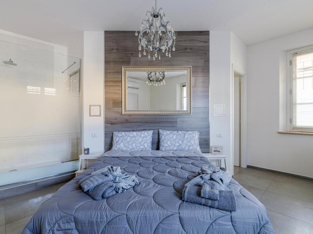 a bedroom with a bed and a chandelier at House Sabbioneta in Sabbioneta