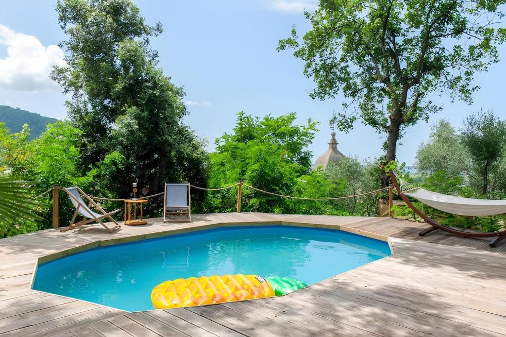 a small swimming pool with a hammock at Ganzo - Tuscany Retreat in Massarosa
