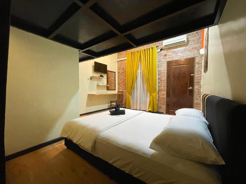 um quarto com uma cama grande e uma cortina amarela em Chalet Tepi Sungai em Pokok Sena