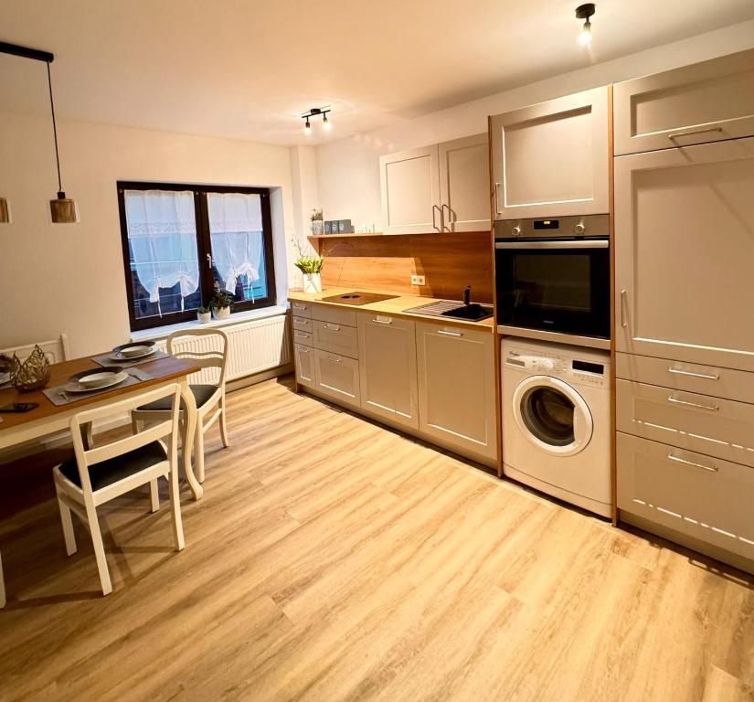 a large kitchen with a table and a microwave at HEIMATliebe Ferienhaus für 4 in Blankenhain
