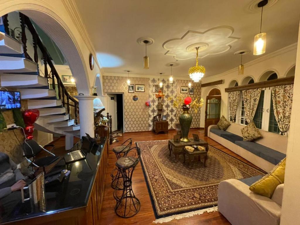 sala de estar con sofá y escalera en Heritage Rose Inn, en Srinagar