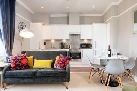 Central, Stunning 2 Bed Apartment with Parking! في كامبريدج: غرفة معيشة مع أريكة وطاولة
