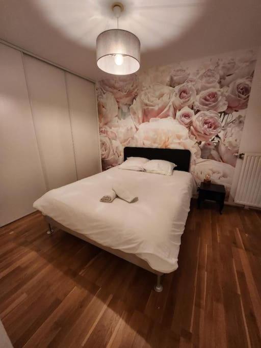- une chambre avec un lit orné de fleurs sur le mur dans l'établissement Bel appartement avec fibre et parking, à Massy