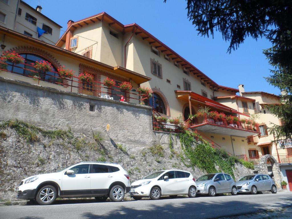un gruppo di auto parcheggiate di fronte a un edificio di Grotta dei Colombi a Scanno