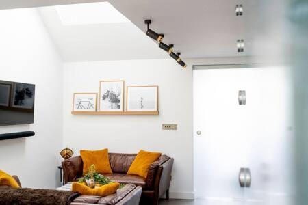 a living room with a brown couch and a door at Stylish Cambridge Home with free parking in Cambridge