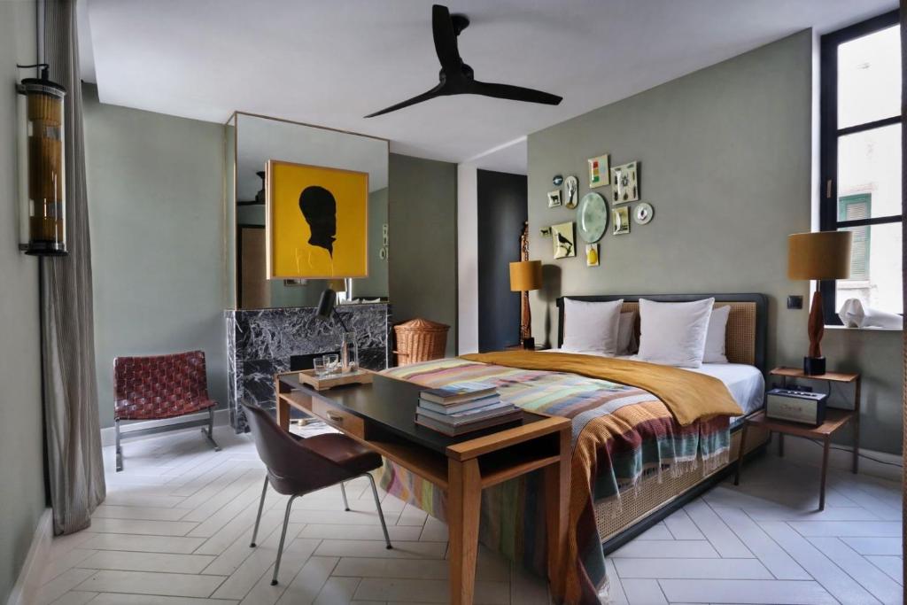 sypialnia z łóżkiem i biurkiem oraz łóżko o wymiarach 6 x 6 x 6 w obiekcie Villa Augustine w mieście Tanger