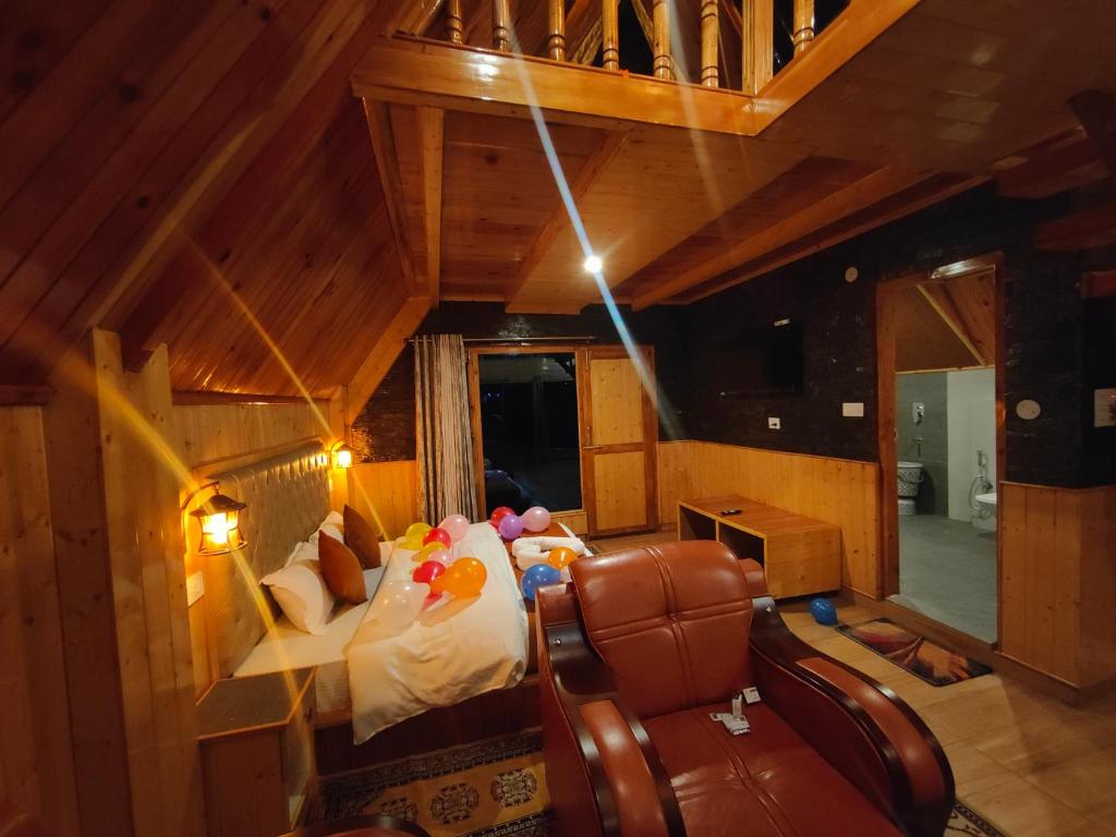 una vista sul soffitto di una camera da letto con un letto e una sedia di Avalanche Cottages a Kasol