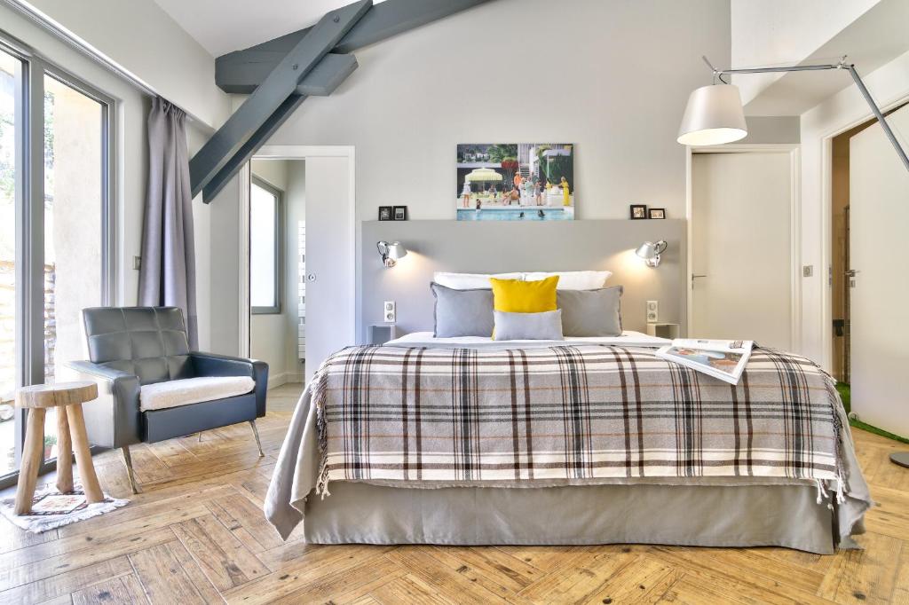 1 dormitorio con 1 cama y 1 silla en Le Florida Auberge contemporaine, en Castéra-Verduzan