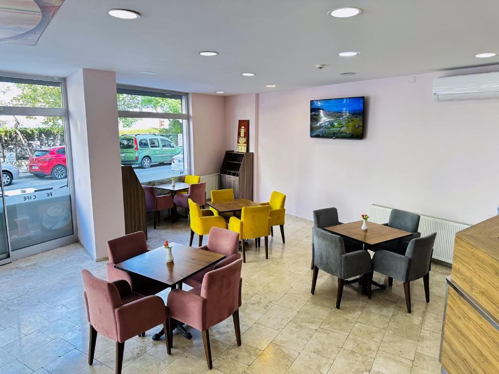 une salle à manger avec des tables et des chaises dans un restaurant dans l'établissement Punta Vista Otel, à Izmir