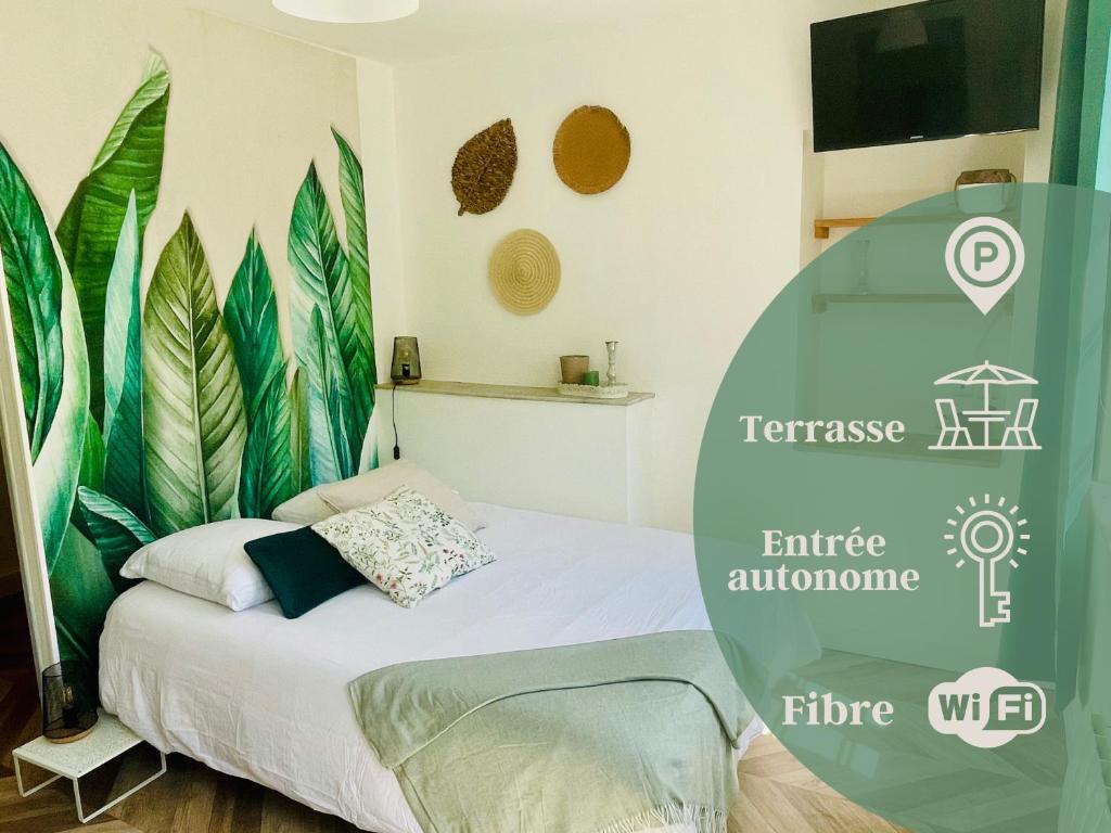 a bedroom with a bed with a poster of leaves at Le Tropical - Studio avec terrasse in Angoulême