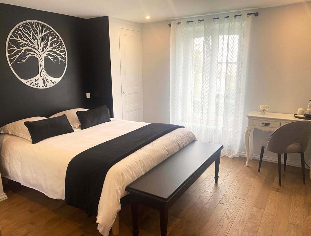 um quarto com uma cama com uma imagem de árvore na parede em Au bois Noël - Le Cerisier em Lescherolles