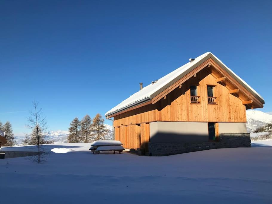 a wooden barn with snow on the ground at chalet montagne la lupina in Les Orres