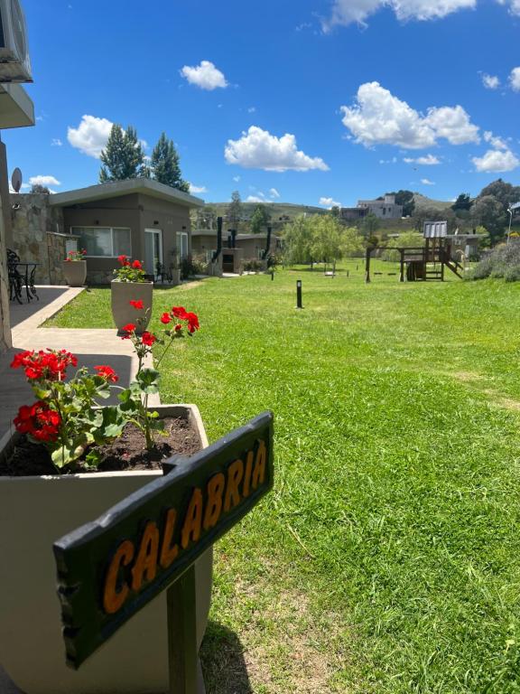 un panneau pour une cour avec des fleurs dans un champ dans l'établissement Tandil del Lago, à Tandil