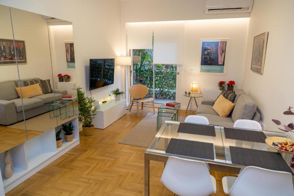 ein Wohnzimmer mit einem Tisch und einem Sofa in der Unterkunft Comfort & Elegance in Kolonaki - 2BD Apt in Athen