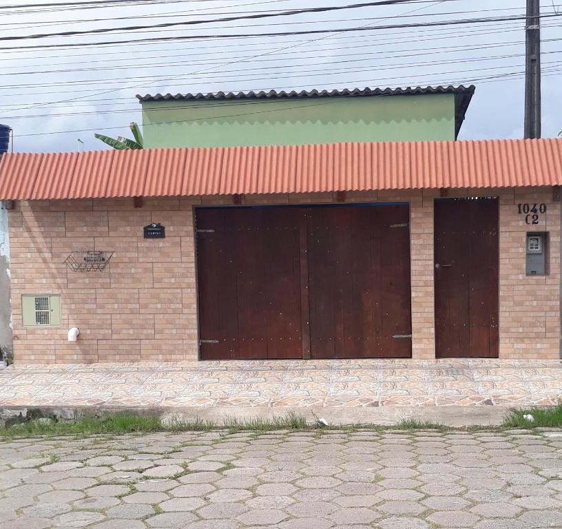 a brick building with two large garage doors at CASA TEMPORADA PERUIBE in Peruíbe