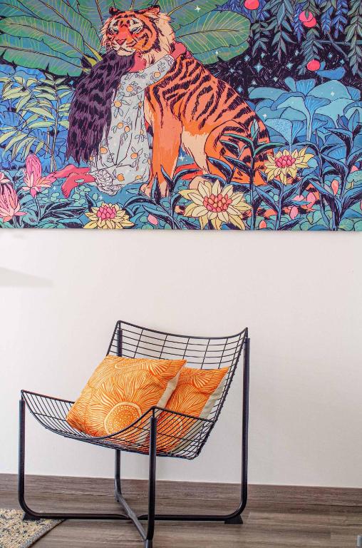 a chair in front of a painting of a tiger at Pine House - Faro Airport, Beach and City Center in Faro