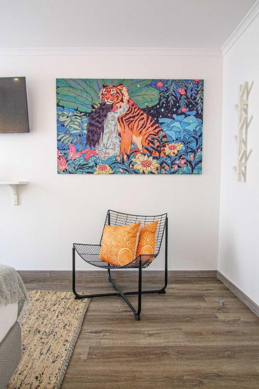 a bench in a room with a painting on the wall at Pine House - Faro Airport, Beach and City Center in Faro