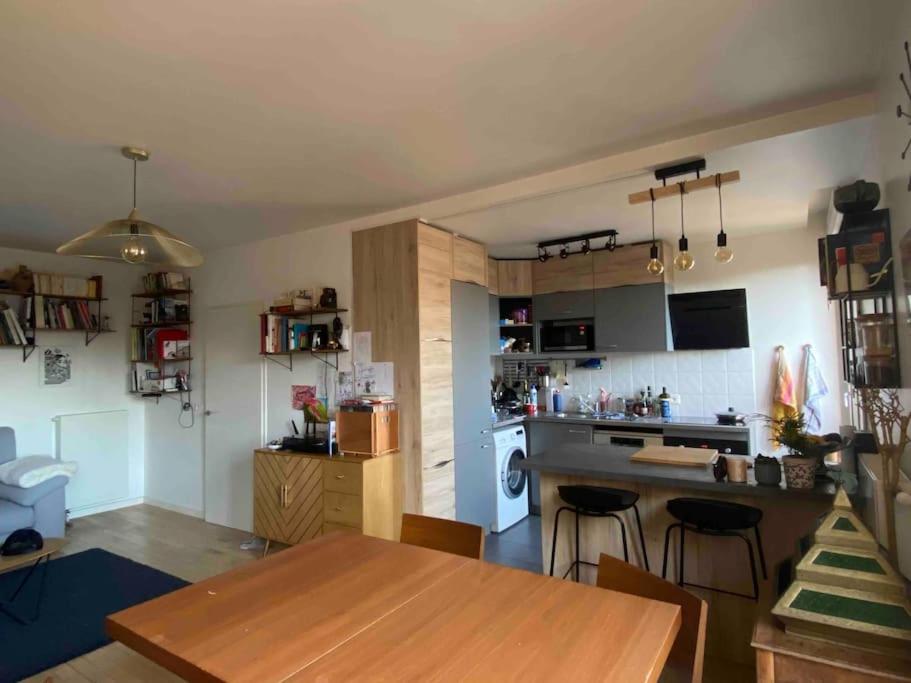 une cuisine avec une table en bois et un comptoir de cuisine dans l'établissement Nice duplex flat in Saint-Denis 1km Stade de France, à Saint-Denis