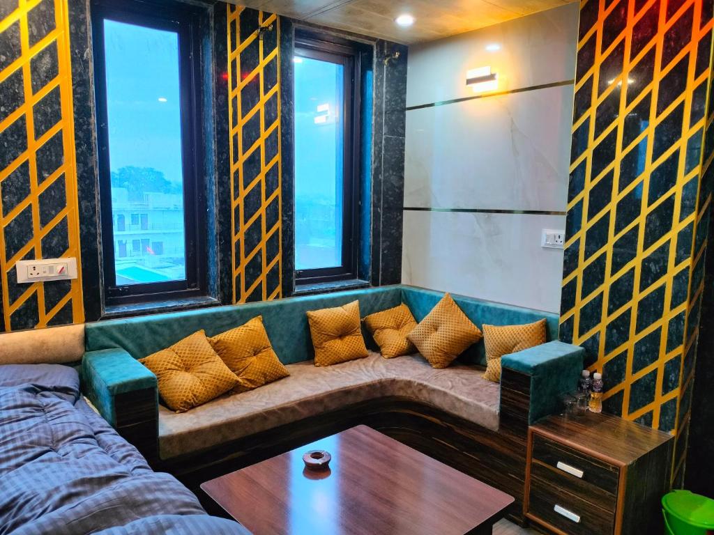 a green couch in a room with windows at Hotel Prem Shanti Inn in Dhaulpur