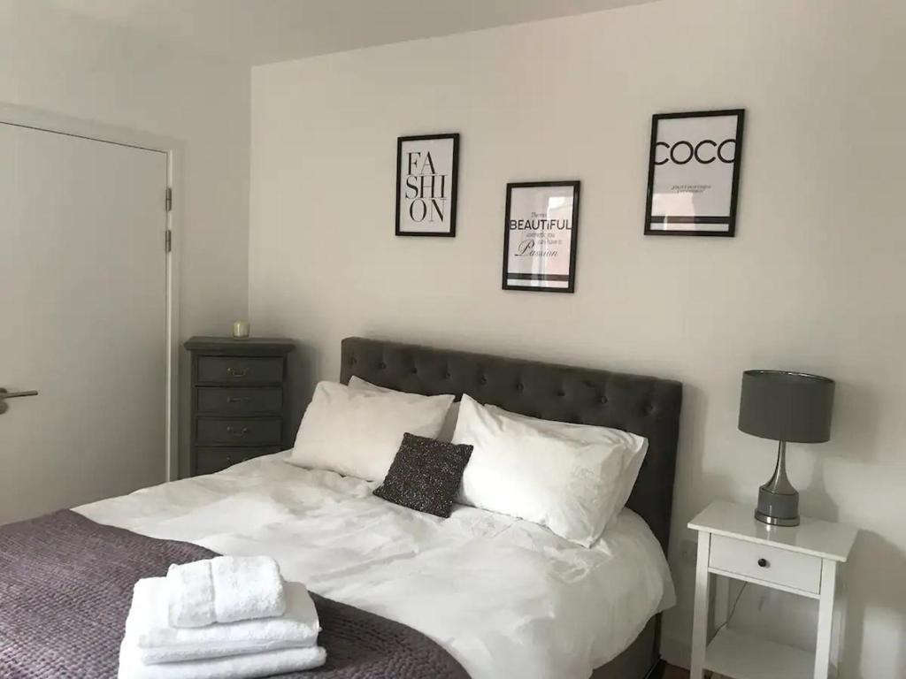 Una cama con sábanas blancas y almohadas en un dormitorio en Central Charm Dwelling, en Londres