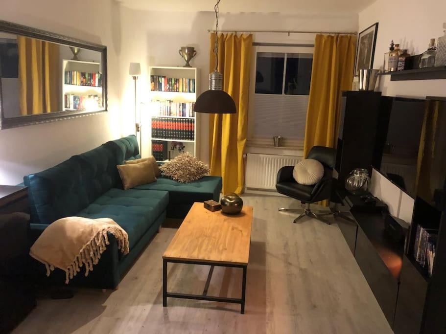 een woonkamer met een groene bank en een salontafel bij Eresburg Apartment. in Marsberg