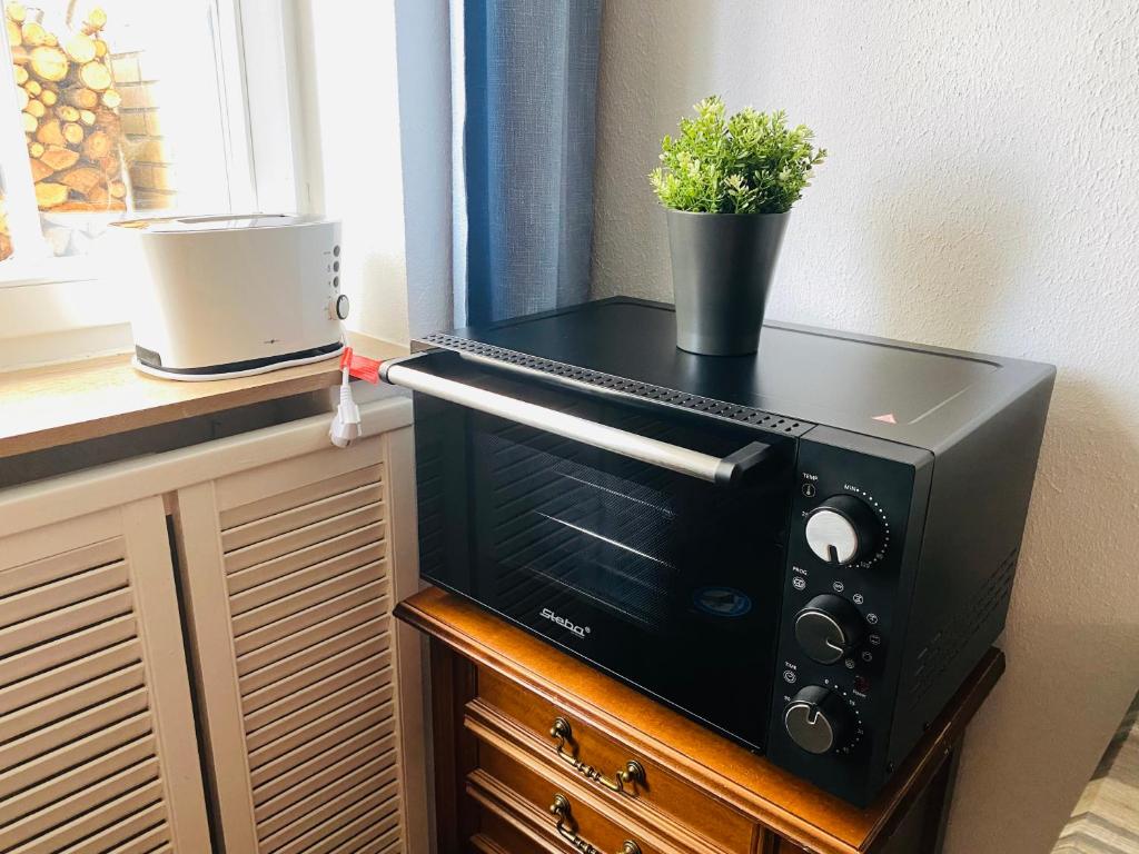 a black microwave sitting on top of a table at Hills Hut in Langelsheim