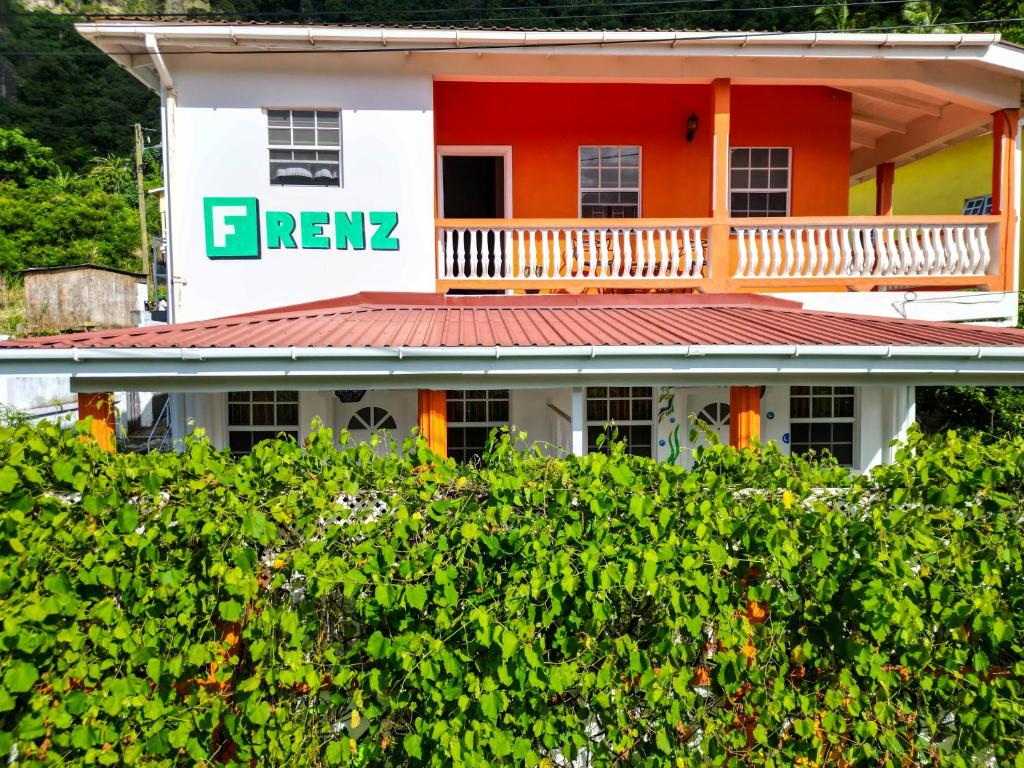 una casa naranja y blanca con un cartel en ella en Frenz en Soufrière