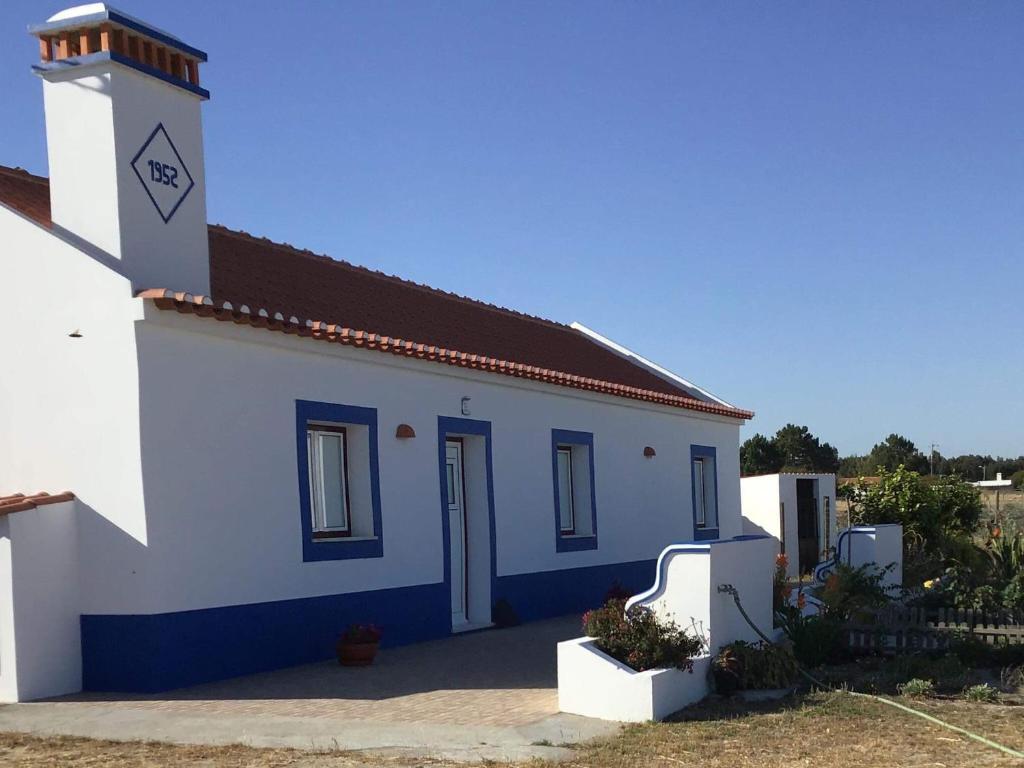 a small white building with a red roof at Monte da Palmeirinha in Vila Nova de Milfontes