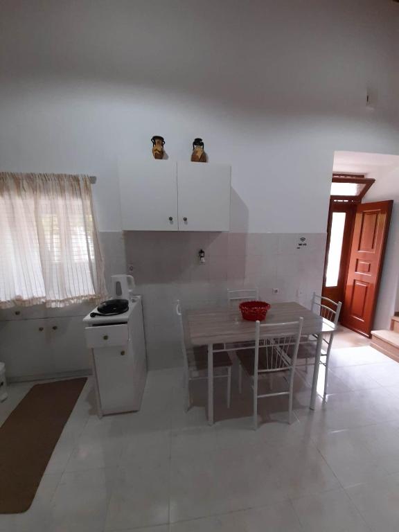 a white kitchen with a table and a table and chairs at Areti's house in Meyisti