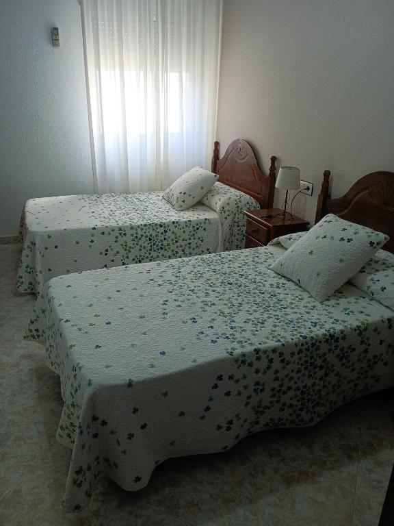 1 dormitorio con 2 camas y ventana en EL ABAD en Abadía