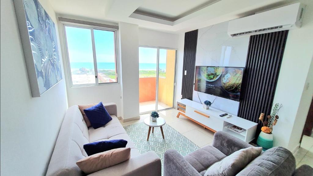 sala de estar con sofá y TV de pantalla plana en Suite con Vista al Mar, Piscinas, Jacuzzi, Wifi, en Playas