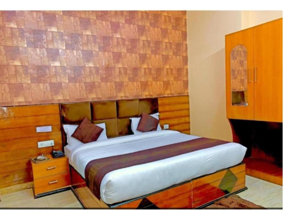 a bedroom with a large bed with a wooden headboard at Hotel Highway, Udhampur in Udhampur