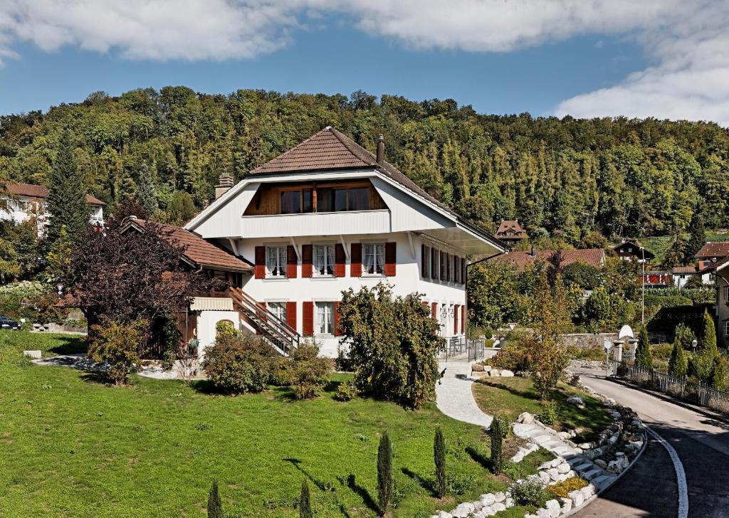 een huis in het midden van een groen veld bij Ferienwohnungen Hotel Eden Spiez in Spiez