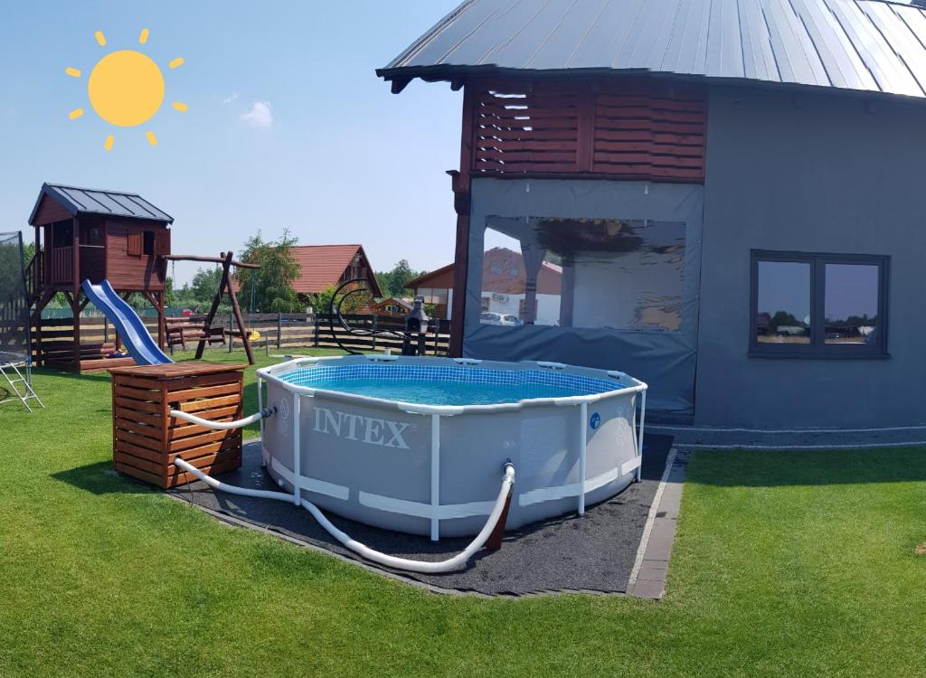 a hot tub in a yard next to a house at Revela Domki Całoroczne Boszkowo in Boszkowo