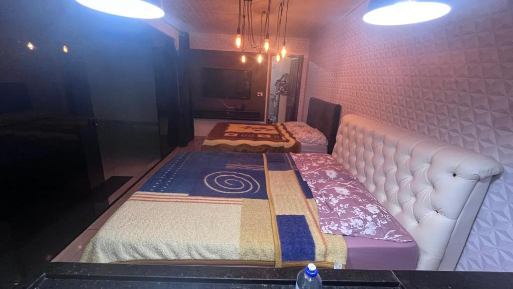 2 camas sentadas en una habitación con luces en Quarto amplo com tv geladeira e fogão en Rio Negro