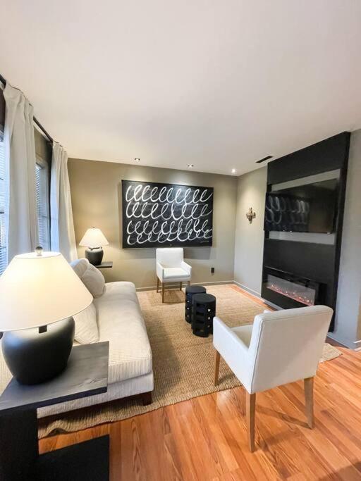 a living room with a white couch and white chairs at Luxury Warehouse District Condo in Durham