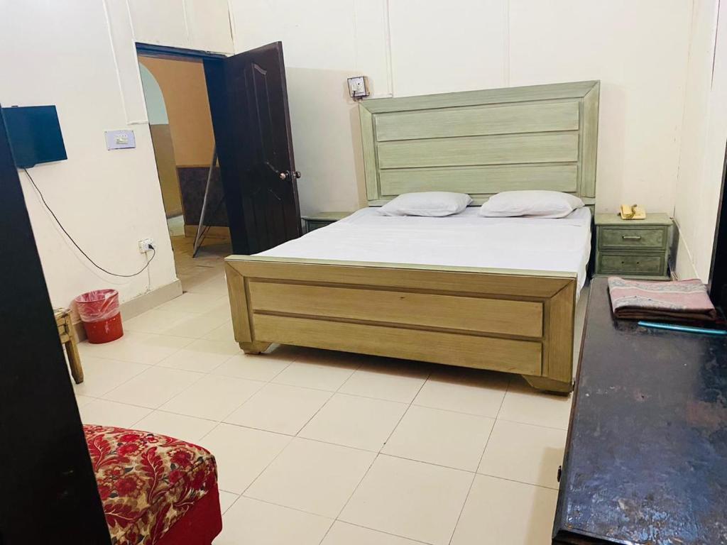 1 dormitorio con 1 cama con cabecero de madera en Hotel New Star, en Multán