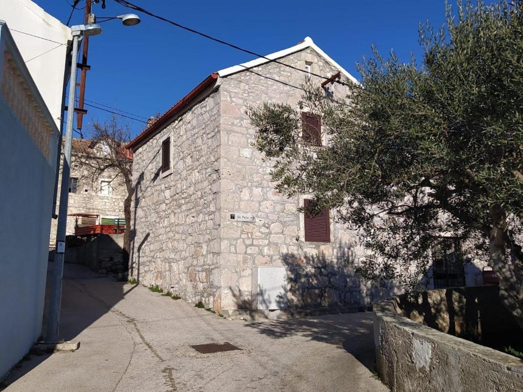 un antiguo edificio de piedra al lado de una calle en Adorable home with private terrace, en Kaprije