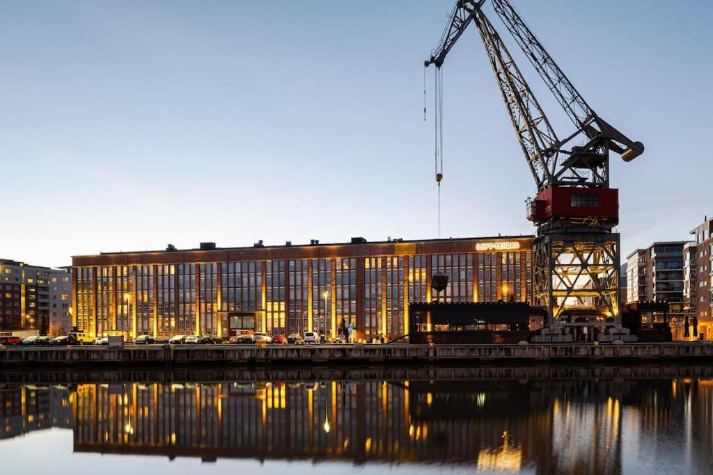 a large building with a crane in front of it at Historical place by the river Aura in Turku